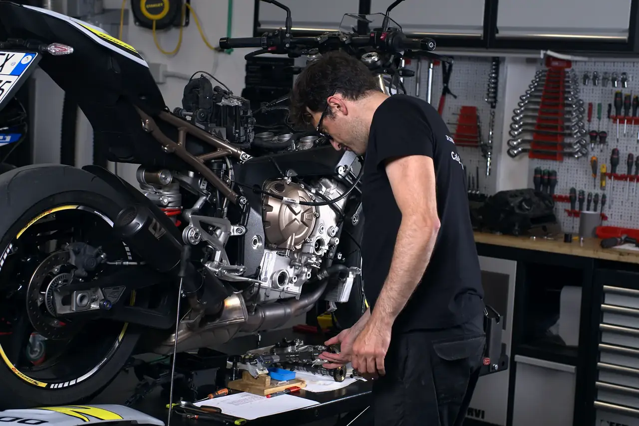 Tecnico al lavoro sulla BMW S 1000 R parzialmente smontata